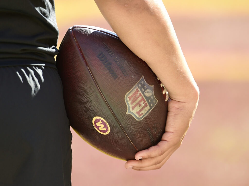 person holding a football with NFL logo