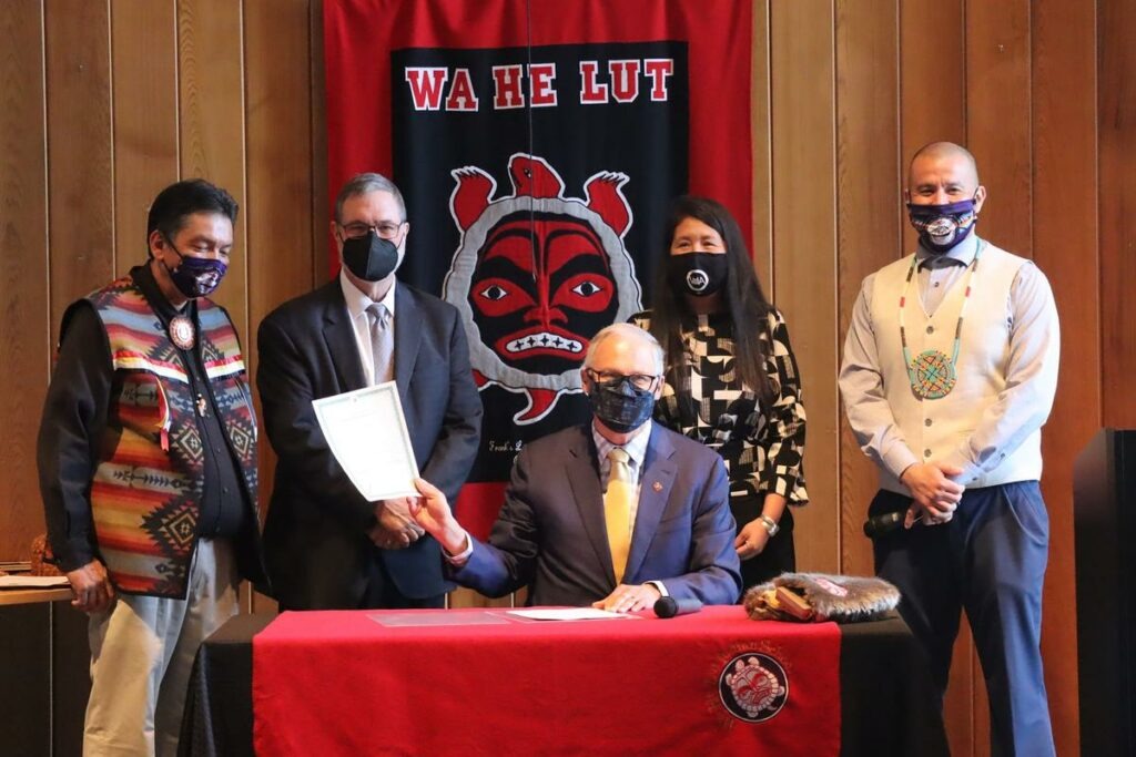 Washington Gov. Jay Inslee signed the Billy Frank Jr. statue bill into law at Wa He Lut Indian School on Wednesday. Looking on, from left, were Nisqually Tribal Chairman Ken Choke, Lt. Gov. Denny Heck, state Rep. Debra Lekanoff and tribal councilman Willie Frank III. CREDIT: Tom Banse/N3