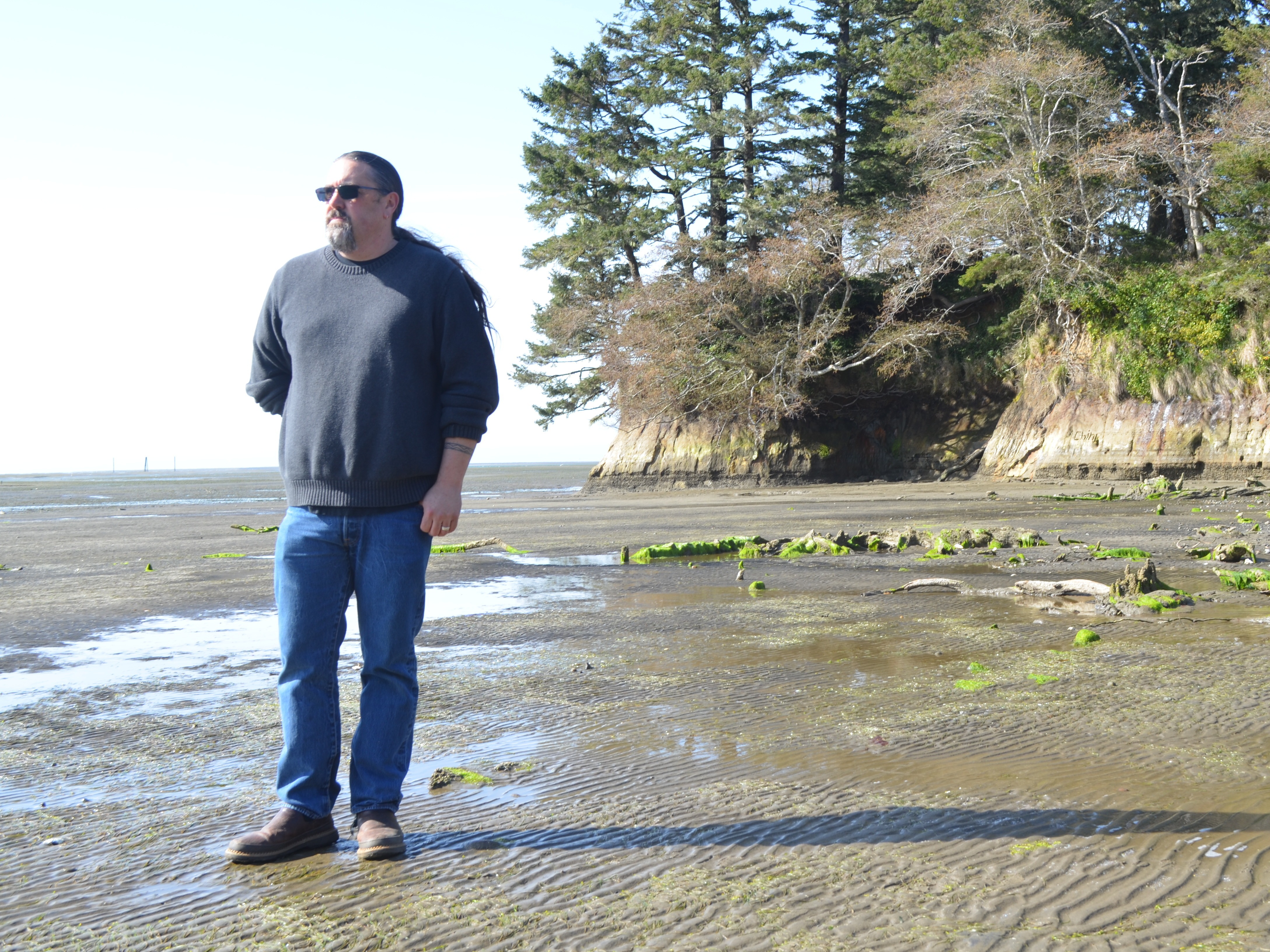 Tony Johnson is chair of the Chinook Indian Nation, a federally unrecognized tribe. He stands on a Willapa Bay, Wash., beach, where he got married and not far from where his ancestors lived. CREDIT: Eilis O'Neill/KUOW