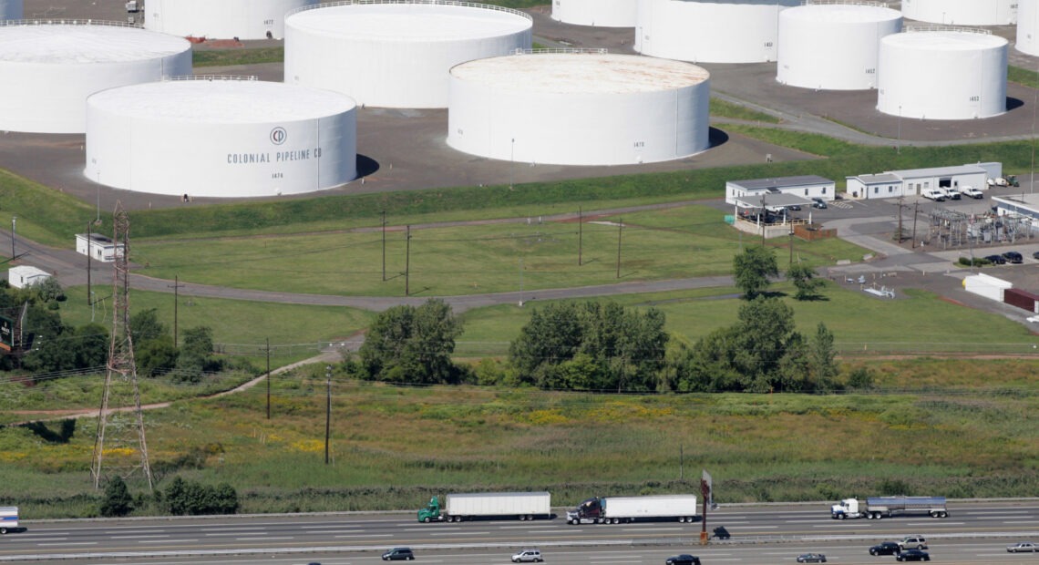 Traffic on I-95 passes oil storage tanks owned by the Colonial Pipeline Co. in Linden, N.J. An cybersecurity attack has shut down Colonial Pipeline, a major transporter of gasoline along the East Coast. CREDIT: Mark Lennihan/AP