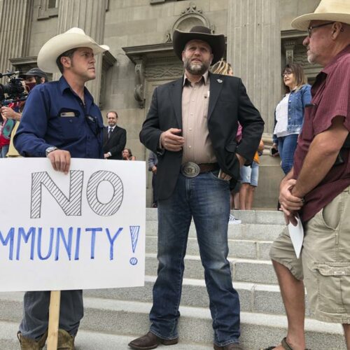 Ammon Bundy, center, who led the Malheur National Wildlife Refuge occupation, stands on the Idaho Statehouse steps in Boise. Mainstream and far-right Republicans are battling for control of the party and the state in deeply conservative Idaho. CREDIT: Keith Ridler/AP