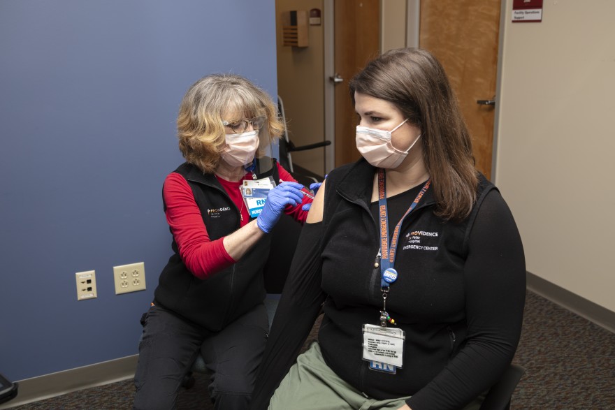 A nurse gives a person a vaccination.