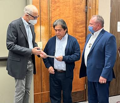 Burt Logan and Billy Friend present Chairman Samuel Penney with a check.