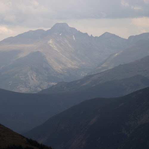 A bird's eye view of the Rocky Mountain range in varying shades of blue and grey.