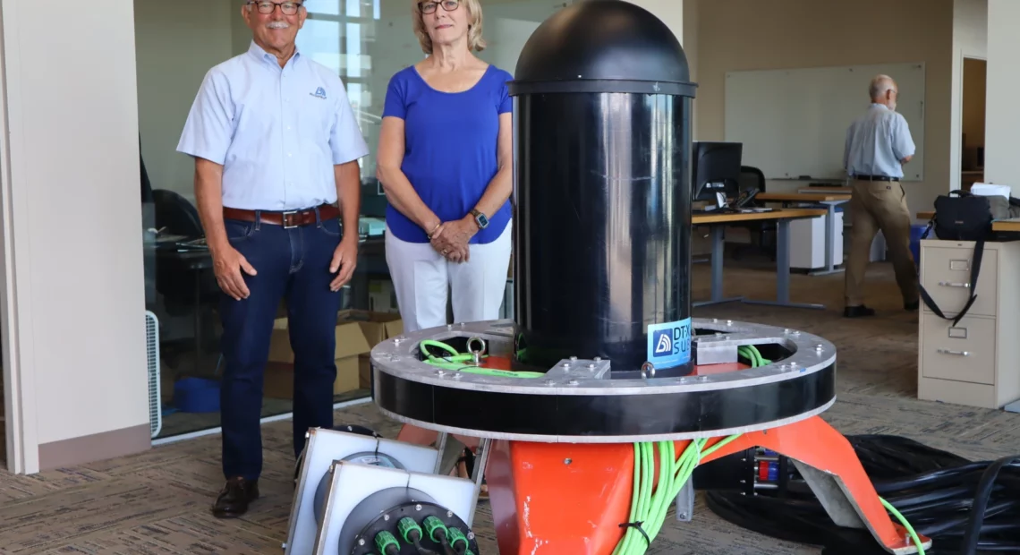 Tim and Bev Acker, CEO and CFO respectively of Biosonics, stand beside the Seattle company’s new ocean-bottom sonar device, which is designed to facilitate marine energy permitting by identifying and tracking nearby sea life.