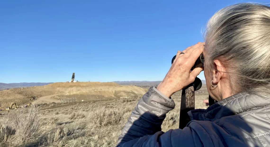 While hiking, Nancy Lust, with Friends of Rocky Top, watches a truck dump waste into a landfill in Yakima County. Lust lives near the landfill and has fought to learn more about what's getting disposed of near her home.