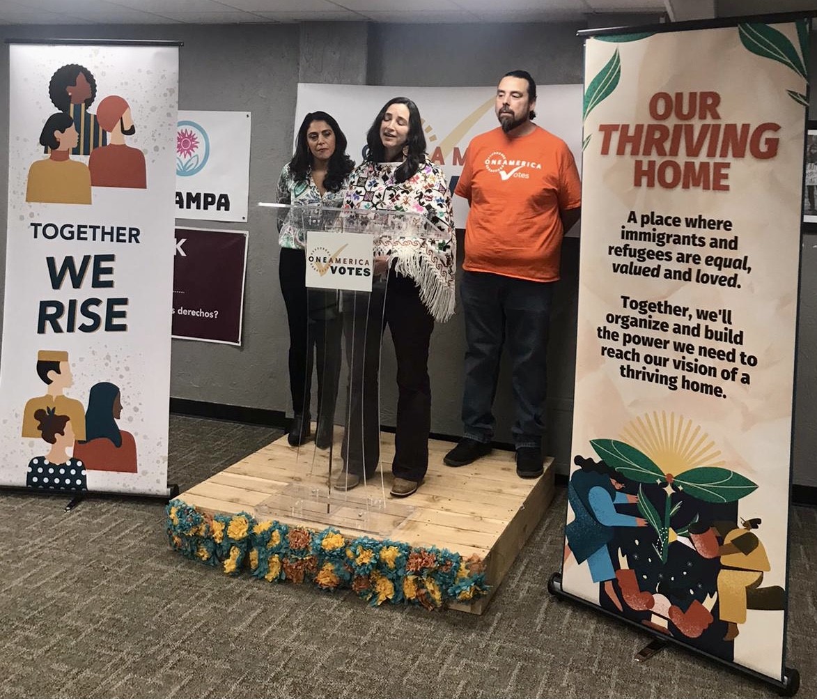 Three people stand on a podium