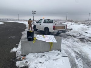 A man stands near a truck in the snow.