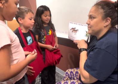 a teacher showing a book to students