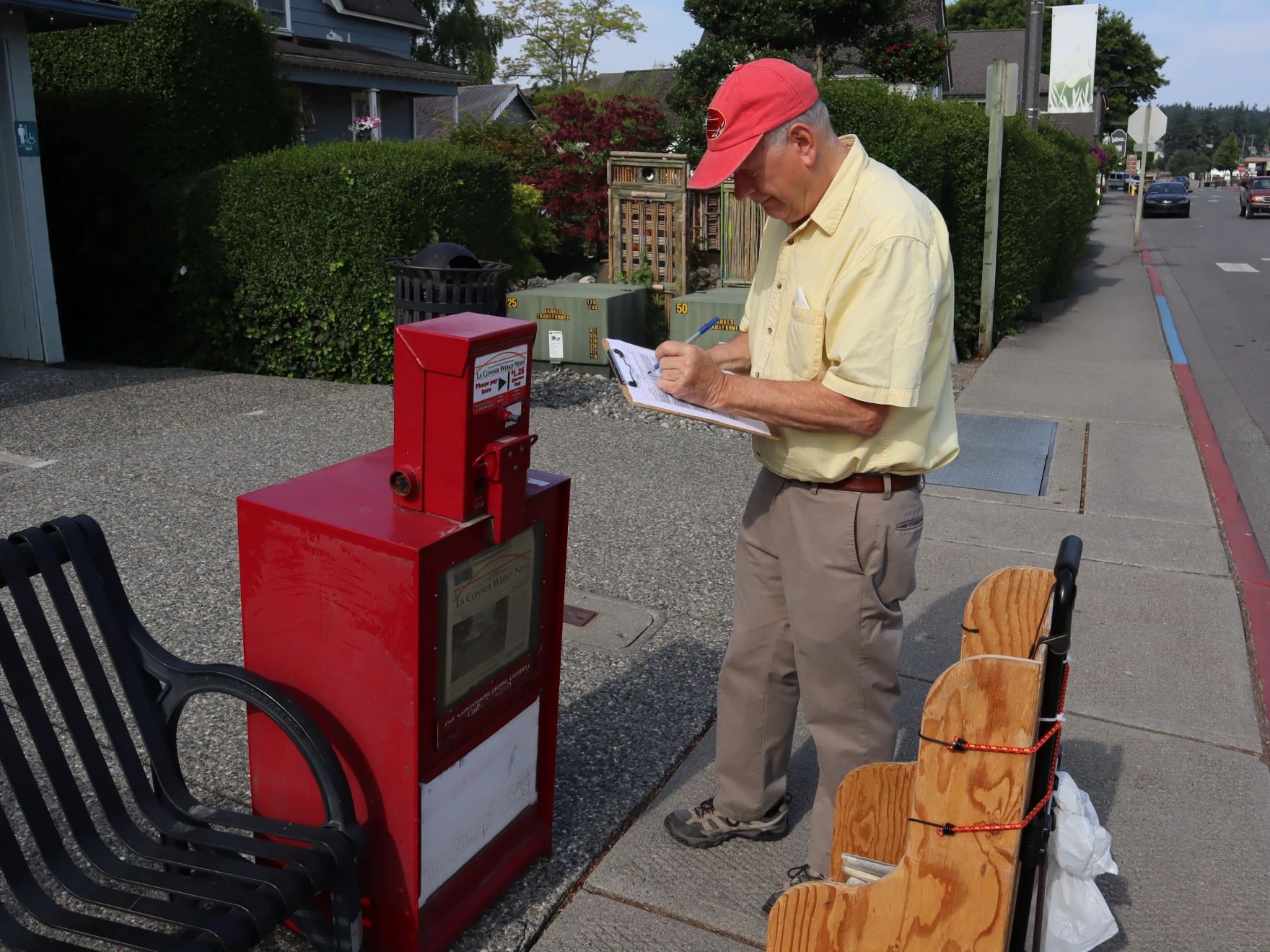 La Conner Weekly News' editor and publisher Ken Stern uses a clipboard to track how many copies of the weekly paper are sold at the different stops around town, including newspaper boxes, the local grocery store, and several coffee shops nearby. He says he's noticed a decline in the number of papers sold from the boxes over the years but wants to keep them available