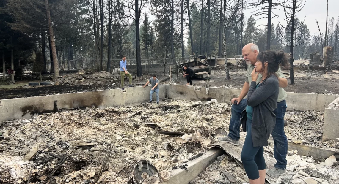 Mike and Stephanie Zappone comfort each other recently amid the ashes of their home in Medical Lake