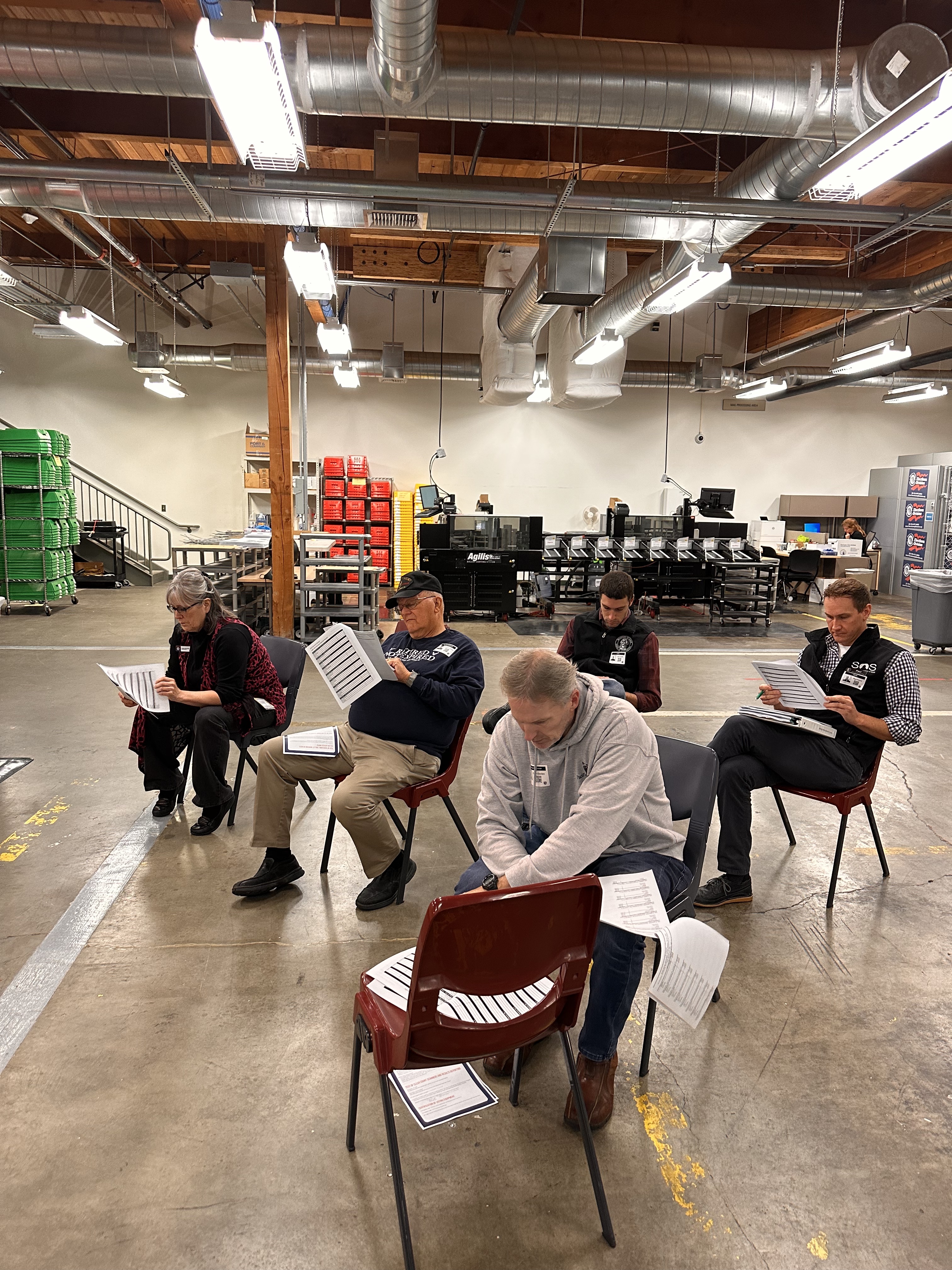 Observers, state and county officials sit and compare the results from the test. (Credit: Lauren Gallup / NWPB)