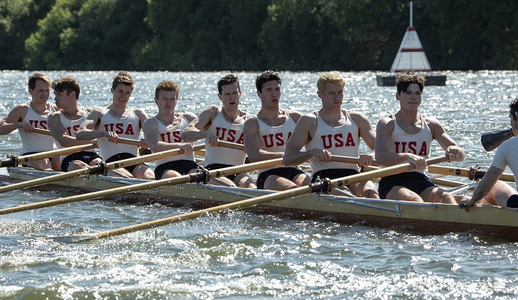 Image from the movie, Boys in the Boat, showing the team rowing.