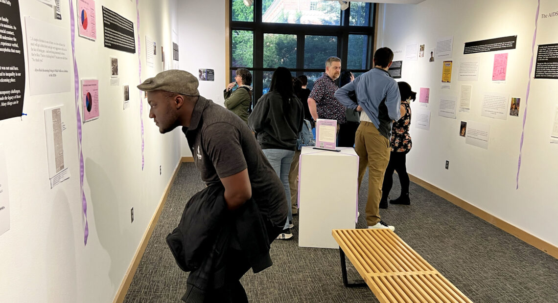 A crowd studies the exhibit “Sweeter Than the Onions: Stories of Queer Resilience in Walla Walla,” at Whitman College. (Credit: Courtney Flatt, Northwest News Network)