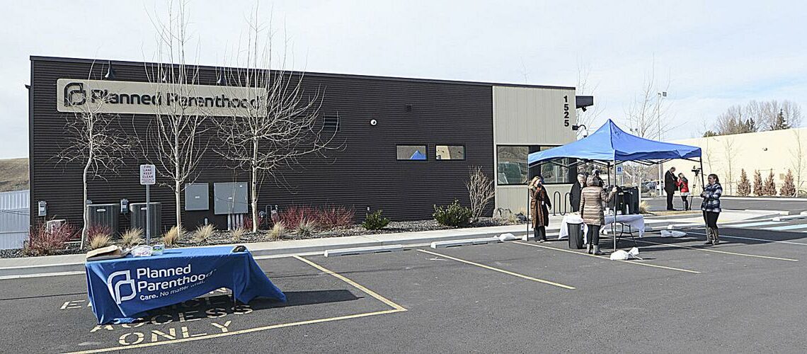 A Planned Parenthood building is pictured. A table and a blue tent is pictured in the parking lot in front of the building.