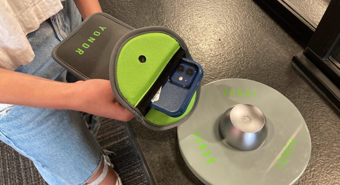 A student holds her phone pouch over the Yondr magnet.