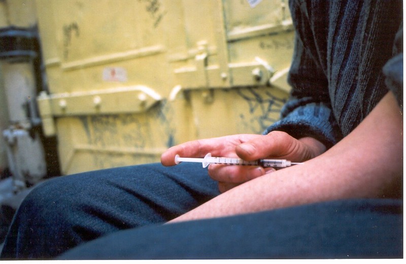 Person using drugs in an alley